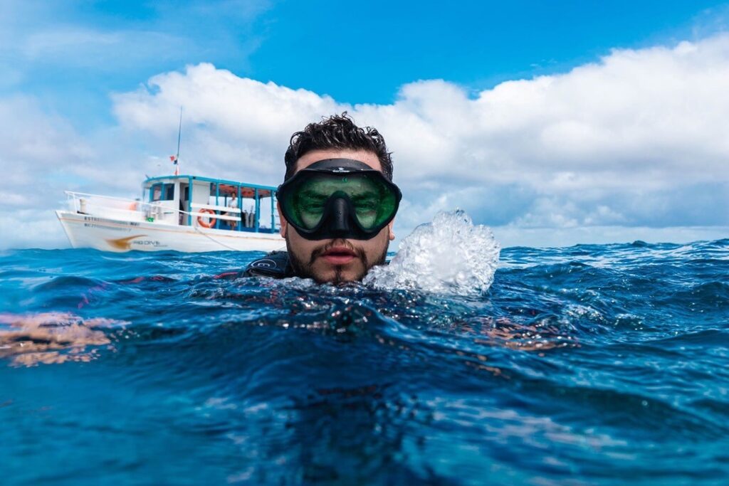 Diver at the surface with the dive boat behind